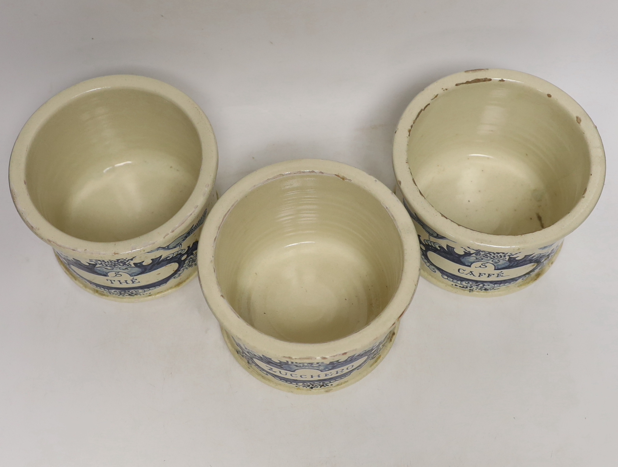 Three French cream and blue glazed storage jars and covers, Caffé, Thé and Zucchero, 18cm high